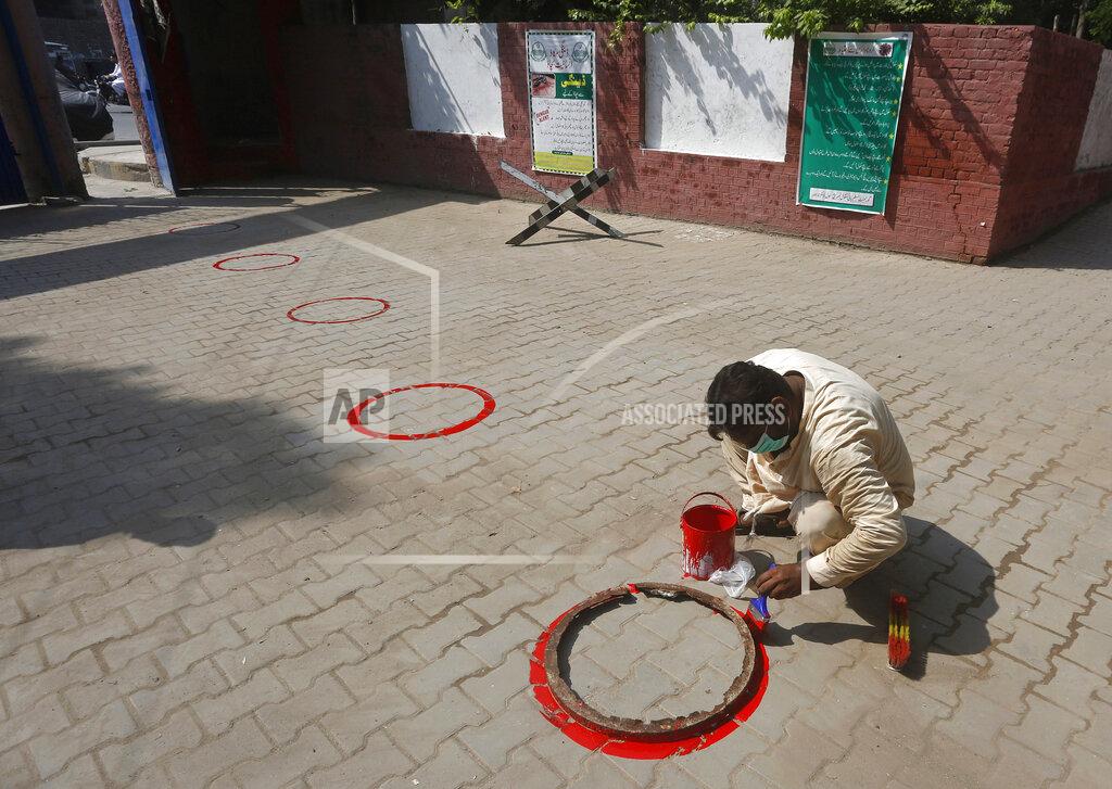 K.m. Chaudary A worker paints circles for social distance at an entry gate of a school as preparation for reopening of educational institutions that were closed in March are finalized, in Lahore, Pakistan, Monday, Sept. 14, 2020. Education officials in Pakistan say authorities will start reopening educational institutions from Sept. 15 amid a steady decline in coronavirus deaths and infections. (AP Photo/K.M. Chaudary)