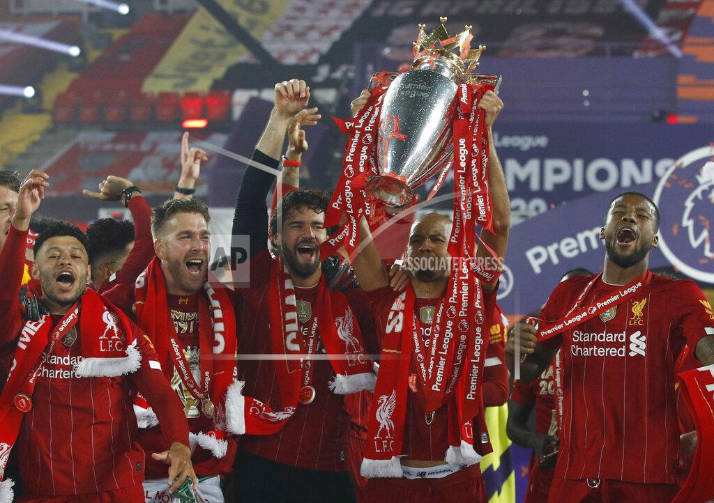 Phil Noble Liverpool's Fabinho and team members celebrate with the English Premier League trophy after it was presented following the Premier League soccer match between Liverpool and Chelsea at Anfield stadium in Liverpool, England, Wednesday, July 22, 2020. (Phil Noble/Pool via AP)