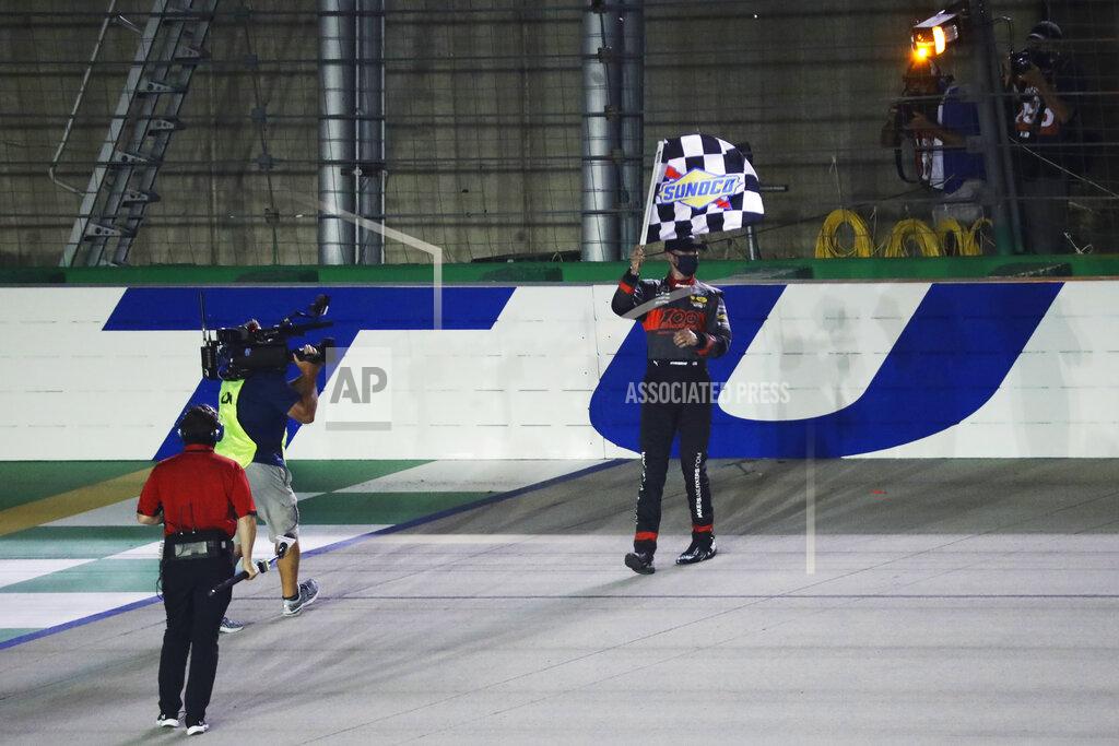 Mark Humphrey Austin Cindric waves the checkered flag after a NASCAR Xfinity Series auto race Thursday, July 9, 2020, in Sparta, Ky. (AP Photo/Mark Humphrey)