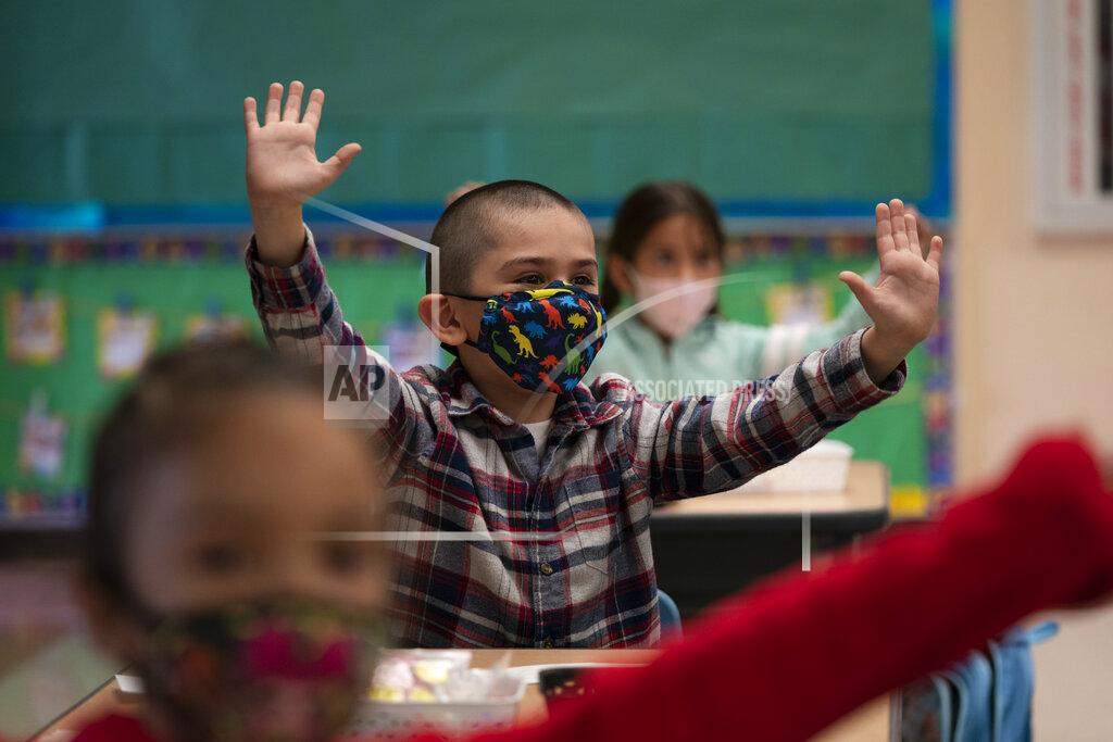 FILE - In this April 13, 2021, file photo, kindergarten students participate in a classroom activity on the first day of in-person learning at Maurice Sendak Elementary School in Los Angeles. All 4-year-olds in California could go to kindergarten for free under a new proposal Wednesday, May 12, 2021, from Gov. Gavin Newsom's administration, part of a broad new education spending package made possible by the state's surprise budget surplus. (AP Photo/Jae C. Hong, File)
