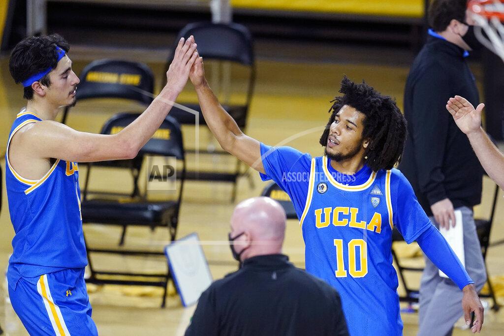 Ross D. Franklin UCLA guard Tyger Campbell (10) gives a high-five to Jaime Jaquez Jr. as time expires in overtime of the team's NCAA college basketball game against Arizona State on Thursday, Jan. 7, 2021, in Tempe, Ariz. UCLA won 81-75. (AP Photo/Ross D. Franklin)