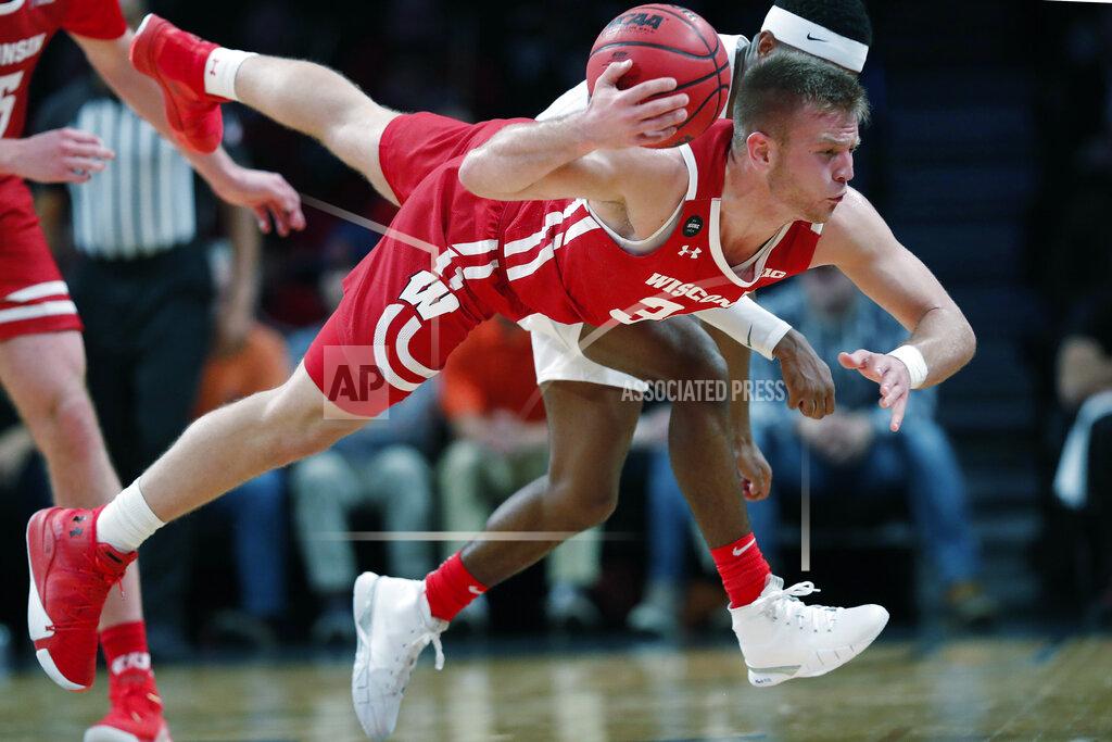 Kathy Willens Wisconsin guard Brad Davison (34) tries to pass to a teammate as he falls to the floor during the second half of an NCAA college basketball game against Richmond in the Legends Classic, Monday, Nov. 25, 2019, in New York. Richmond defeated Wisconsin 62-52. (AP Photo/Kathy Willens)