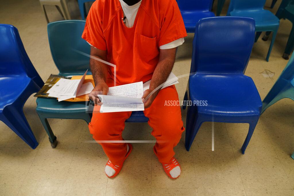Gerald Herbert Immigration detainee Alexander Martinez shows his handwritten notations of allegations of abusive treatment, as he speaks during an interview with The Associated Press inside the Winn Correctional Center in Winnfield, La., Friday, July 30, 2021. (AP Photo/Gerald Herbert)