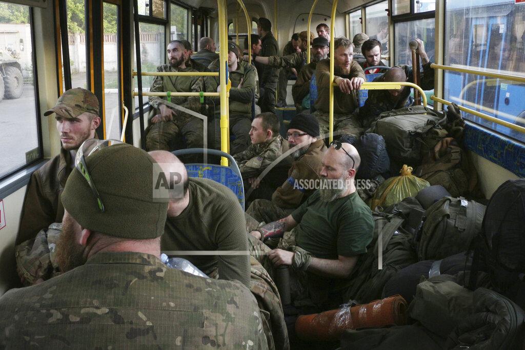 Uncredited Ukrainian servicemen sit in a bus after they were evacuated from the besieged Mariupol's Azovstal steel plant, near a prison in Olyonivka, in territory under the government of the Donetsk People's Republic, eastern Ukraine, Tuesday, May 17, 2022. More than 260 fighters, some severely wounded, were pulled from a steel plant on Monday that is the last redoubt of Ukrainian fighters in the city and transported to two towns controlled by separatists, officials on both sides said. (AP Photo)