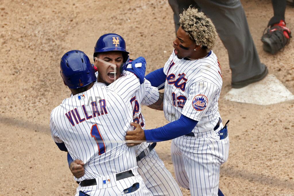 Adam Hunger New York Mets' Javier Baez celebrates with Jonathan Villar and Francisco Lindor, right, after scoring the game winning run against the Miami Marlins during the ninth inning of the first game of a baseball doubleheader that started April 11 and was suspended because of rain, Tuesday, Aug. 31, 2021, in New York. The Mets won 6-5. (AP Photo/Adam Hunger)