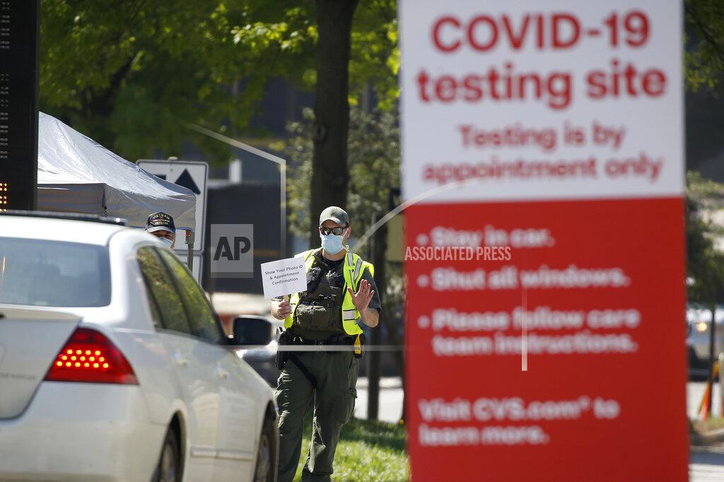 John Bazemore A police officer directs cars into a coronavirus testing facility at Georgia Tech Monday, April 6, 2020, in Atlanta. The testing is by appointment only and requires a referral. (AP Photo/John Bazemore)