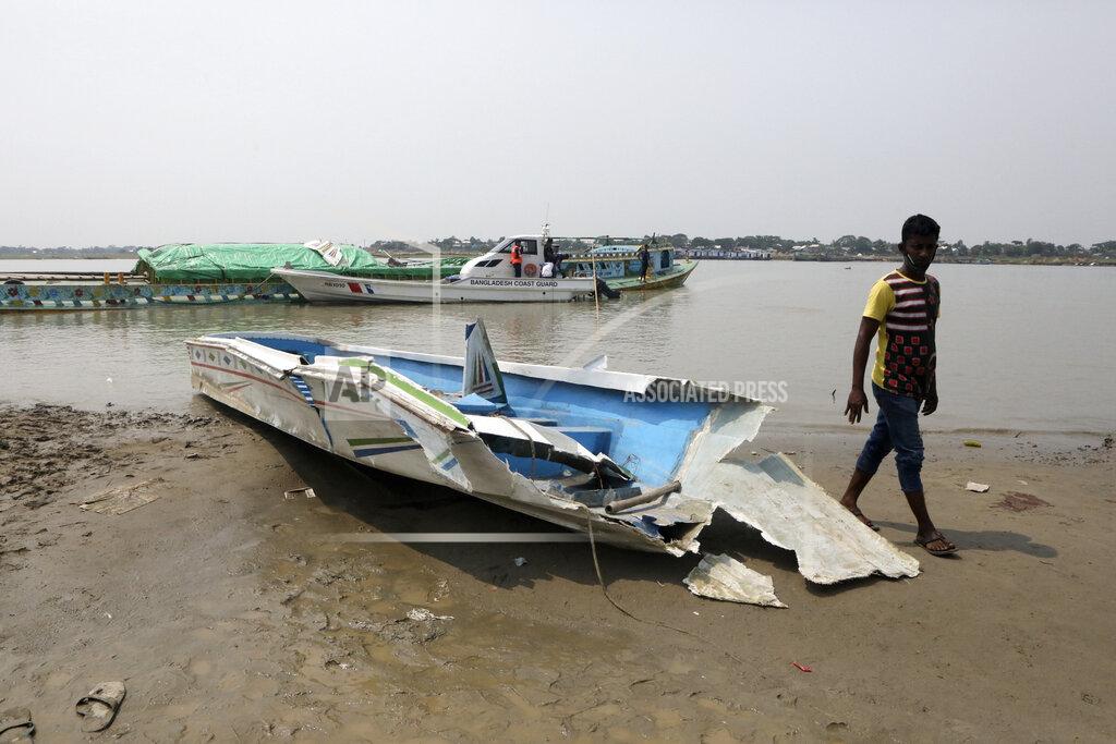 Abdul Goni A man walks past the mangled remains of a speedboat that overturned Monday morning after hitting a cargo boat in River Padma at the Kanthalbari ferry terminal in Madaripur, central Bangladesh, Monday, May 3, 2021. More than two dozen people were killed. (AP Photo/Abdul Goni)