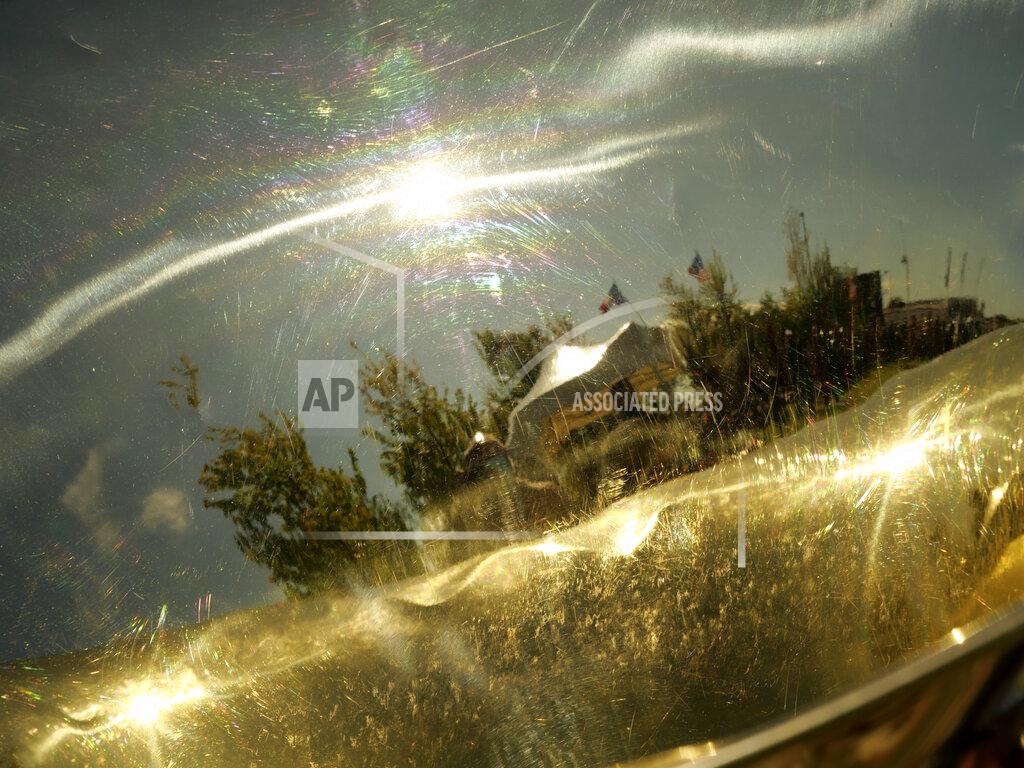 Nicolas Garriga A D-Day ceremony is reflected in a brass instrument in Carentan, Normandy, Friday, June 4, 2021. In a small Normandy town where paratroopers landed in the early hours of D-Day, applauds broke the silence to honor Charles Shay. He was the only veteran to attend the ceremony in Carentan commemorating the 77th anniversary of the assault that led to the end World War II. (AP Photo/Nicolas Garriga)