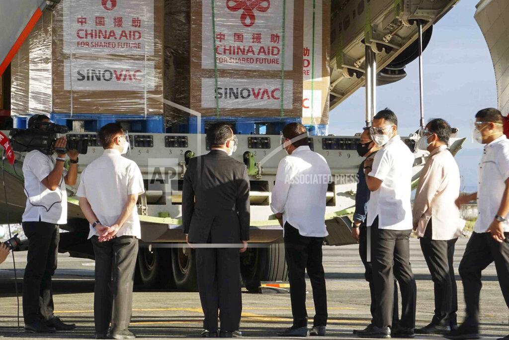 Uncredited In this photo provided by the Presidential Communications Operations Office-Office of the Global Media Public Affairs, Philippine President Rodrigo Duterte, center, looks at a Chinese military plane carrying the first batch of Sinovac vaccine from China at the Villamor Air Base in Manila, Philippines on Sunday Feb. 28, 2021. The Philippines is due to receive its first batch of COVID-19 vaccine Sunday, among the last in Southeast Asia to secure the critical doses despite having the second-highest number of coronavirus infections and deaths in the hard-hit region. (PCOO-OGMPA via AP)