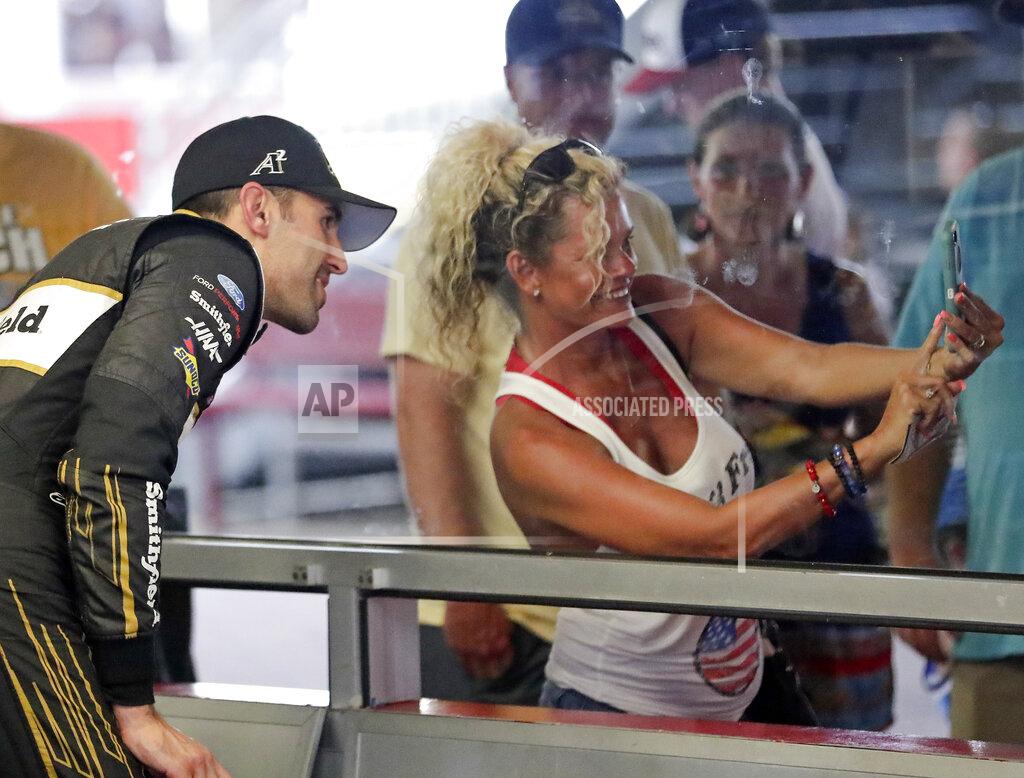 John Raoux Aric Almirola, left, poses for a selfie photo in his garage with a fan during practice for the NASCAR Cup Series auto race at Daytona International Speedway, Thursday, July 4, 2019, in Daytona Beach, Fla. (AP Photo/John Raoux)