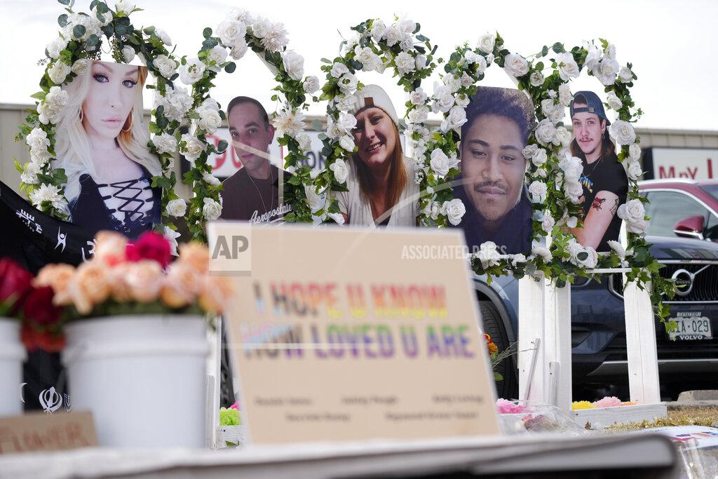 David Zalubowski Photographs of the victims of a mass shooting a gay nightclub look over a table set with free flowers at a makeshift memorial for the victims of a mass shooting over the weekend at a gay nightclub Wednesday, Nov. 23, 2022, in Colorado Springs, Colo. (AP Photo/David Zalubowski)