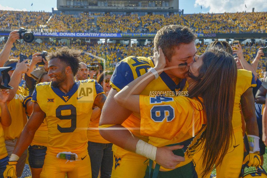 Craig Hudson West Virginia defensive lineman Reese Donahue (46) kisses his girlfriend Sarah Moore after proposing to her following the Mountaineers victory 38-22 over the Kansas in an NCAA college football game against Kansas in Morgantown, W. Va., Saturday Oct. 6, 2018. (Craig Hudson/Charleston Gazette-Mail via AP)