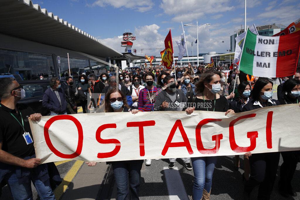 Alessandra Tarantino Alitalia workers hold a banner reading in Italian "Hostages" as they stage a protest at the Rome Leonardo da Vinci airport as unions are discussing with the government the future to relaunch the Italian airline carrier Alitalia, Friday, April 23, 2021. (AP Photo/Alessandra Tarantino)