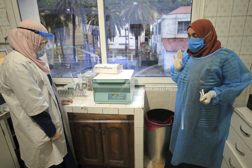 Fateh Guidoum Nurses of a private laboratory work on COVID-19 tests Sunday, Dec.6, 2020 in Algiers. Algeria received rapid antigen testing kits, adding plans to widen access to the tests across the country by March 2021, and increase the number of private laboratories approved to run PCR tests. (AP Photo/Fateh Guidoum)
