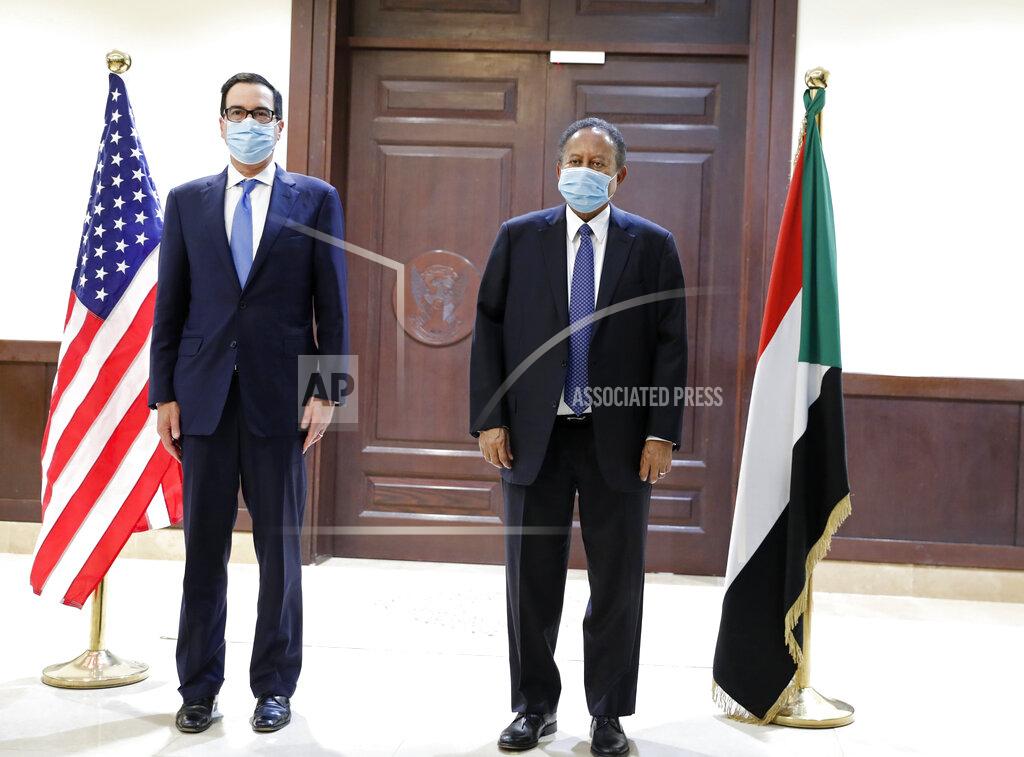 Uncredited Sudanese Prime Minister Abdullah Hamdok, right, welcomes US Treasury Secretary Steven Mnuchin to the Cabinet Building, in Khartoum, Sudan, Wednesday, Jan. 6, 2021. The U.S. and Sudan have agreed to settle the African country's debt to the World Bank. The move comes after Mnuchin arrived in Sudan, the first visit by a senior American official since President Donald trump removed Sudan from the list of state sponsors of terrorism. (AP Photo)
