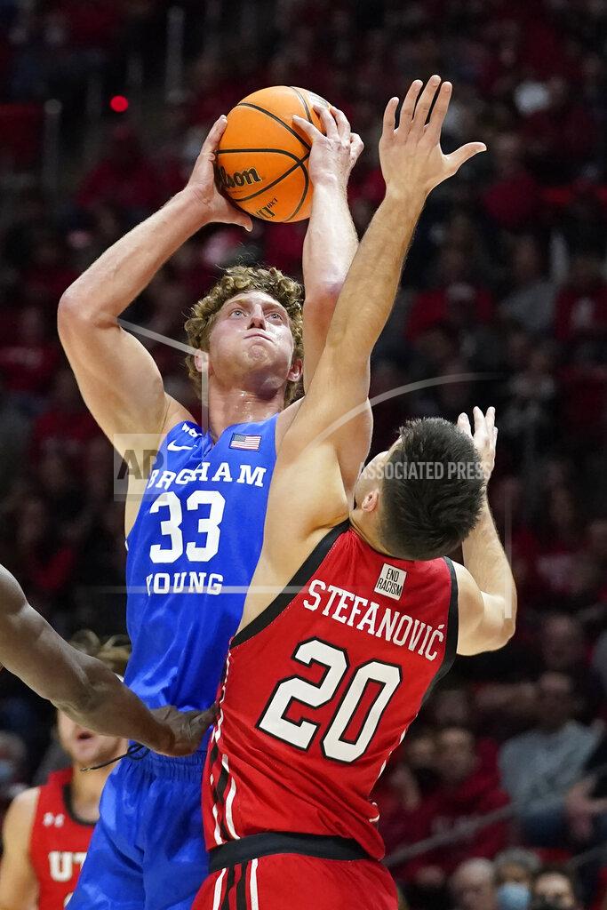 Rick Bowmer BYU forward Caleb Lohner (33) shoots as Utah guard Lazar Stefanovic (20) defends during the first half of an NCAA college basketball game Saturday, Nov. 27, 2021, in Salt Lake City. (AP Photo/Rick Bowmer)