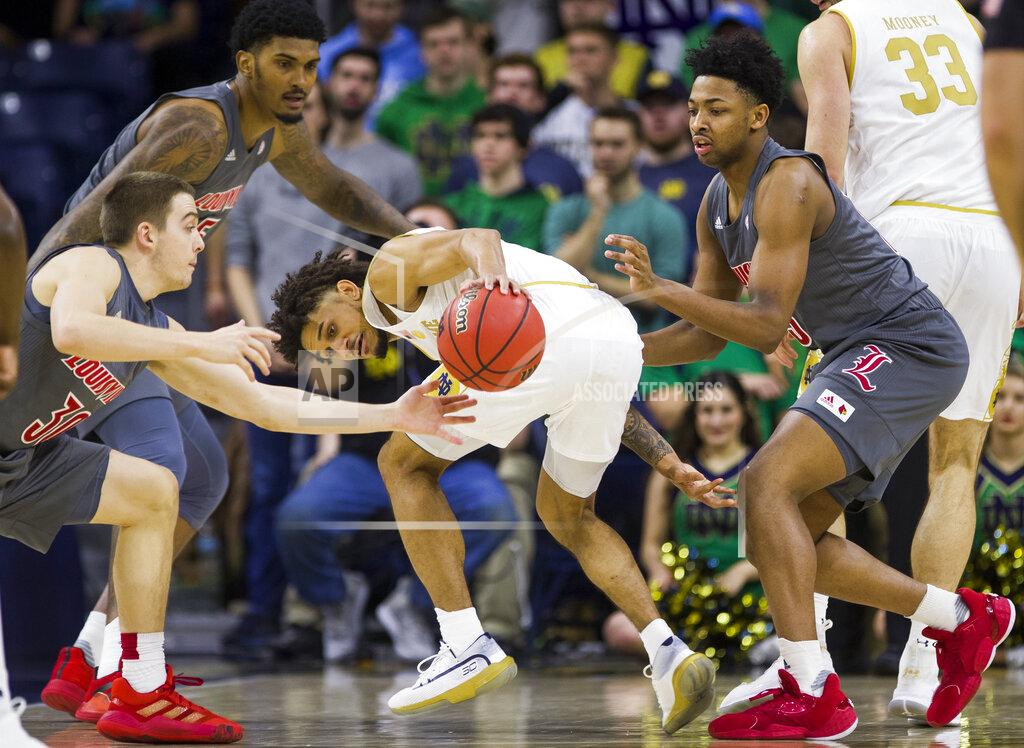Robert Franklin Notre Dame's Prentiss Hubb, center, loses control of the ball as Louisville's Ryan McMahon (30), Malik Williams and David Johnson, right, defend during the first half of an NCAA college basketball game Saturday, Jan. 11, 2020, in South Bend, Ind. (AP Photo/Robert Franklin)