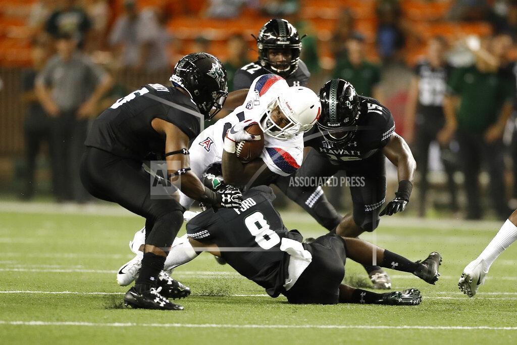 Marco Garcia Arizona running back J.J. Taylor (21) tries to break through the Hawaii defense during an NCAA college football game, Saturday, Aug. 24, 2019, in Honolulu. (AP Photo/Marco Garcia)