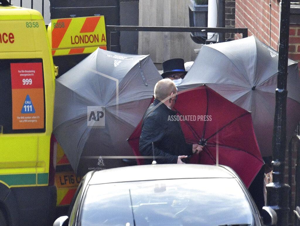 Dominic Lipinski Staff use umbrellas to shield entrance to an ambulance outside the rear of the King Edward VII Hospital in London where Prince Philip is being treated Monday March 1, 2021. (Dominic Lipinski/PA via AP)