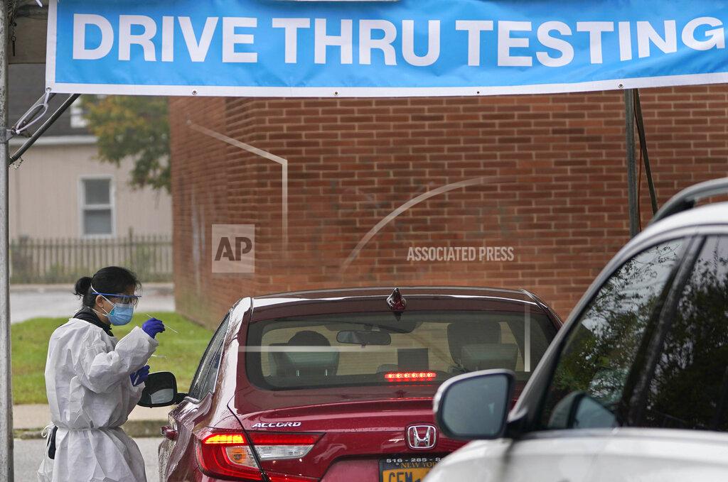 Seth Wenig FILE - In this Wednesday Oct. 21, 2020, file photo a health worker prepares to administer a COVID-19 swab at a drive-thru testing site in Lawrence, N.Y. The the state Department of Health said a tiny fraction of vaccinated New Yorkers have tested positive for COVID-19. (AP Photo/Seth Wenig, File)