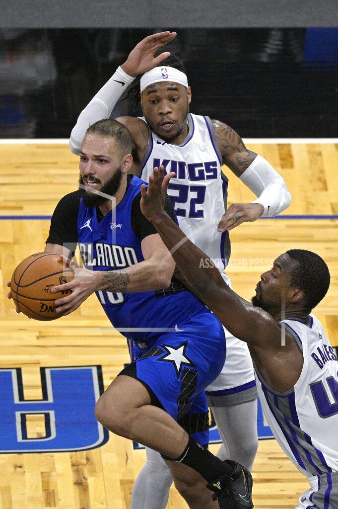 Phelan M. Ebenhack Orlando Magic guard Evan Fournier (10) looks to pass the ball from between Sacramento Kings center Richaun Holmes (22) and forward Harrison Barnes (40) during the second half of an NBA basketball game Wednesday, Jan. 27, 2021, in Orlando, Fla. (AP Photo/Phelan M. Ebenhack)