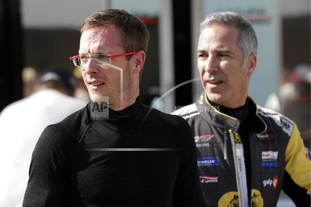 John Raoux FILE - In this Friday, Jan. 3, 2020, file photo, Sebastien Bourdais, left, and Joao Barbosa walk back to their garage after a practice session during testing for the upcoming Rolex 24 hour auto race at Daytona International Speedway in Daytona Beach, Fla. Bourdais spent a day in early November helping IndyCar fine-tune its newest safety innovation. Later that night, he learned he was likely losing his job with a year remaining on his contract. (AP Photo/John Raoux, File)