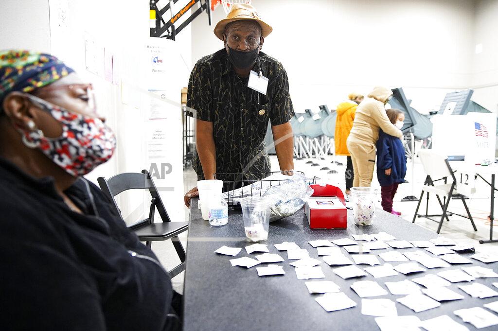 Elizabeth Conley Election judge Herman Williams chats with a poll worker at Victory Houston polling station in Houston, on Friday, Oct. 30, 2020. The location was one of the Harris County's 24-hour locations. (Elizabeth Conley/Houston Chronicle via AP)