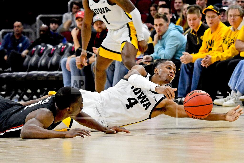 Matt Marton Cincinnati guard Keith Williams, left, fights for a loose ball with Iowa guard Bakari Evelyn (4) during the second half of an NCAA college basketball game Saturday, Dec. 21, 2019, in Chicago. (AP Photo/Matt Marton)