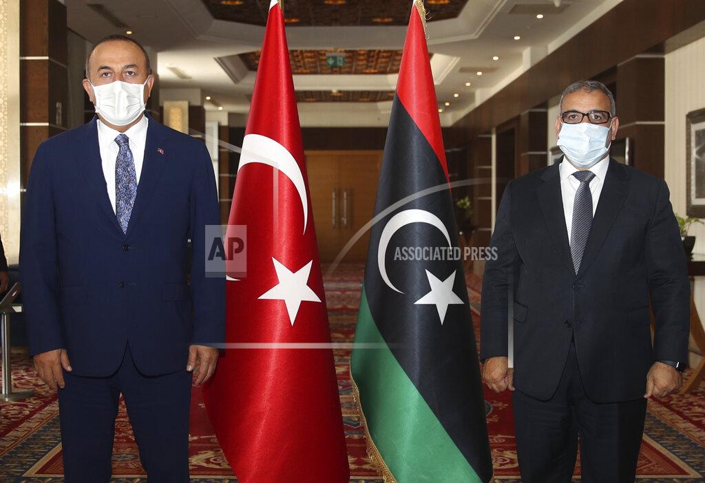 Fatih Aktas FILE - In this Aug. 6, 2020 file photo, Turkey's Foreign Minister Mevlut Cavusoglu, left, and Khalid Al-Mishri, Head of the Libyan High Council of State, pose for a photo before their talks, in Tripoli, Libya. The confirmed death toll from the coronavirus has gone over 50,000 in the Middle East as the pandemic continues. That's according to a count Thursday, Sept. 3, 2020, from The Associated Press, based on official numbers offered by health authorities across the region. Those numbers still may be an undercount, though, as testing in war-torn nations like Libya and Yemen remains extremely limited. (Fatih Aktas/Turkish Foreign Ministry via AP, Pool, File)
