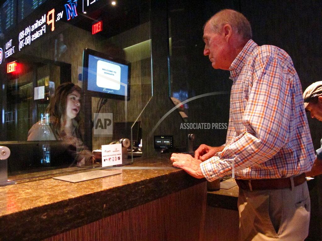 Wayne Parry This Sept. 4, 2019 photo shows a customer checking the odds at the sports book at the Borgata casino in Atlantic City, N.J. Figures released Thursday, Sept. 12, 2019 show more than $293 million was wagered on sports in New Jersey in August, helping Atlantic City's nine casinos increase their revenue by 13% compared to a year ago. (AP Photo/Wayne Parry)