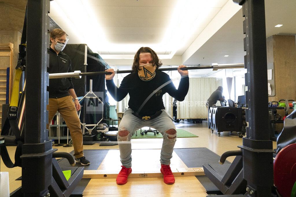 Mark Lennihan Physical therapist Eric Ross, left, watches as Joe DiMeo lifts weights, Monday, Jan. 25, 2021 at NYU Langone Health in New York. The 22-year-old New Jersey resident had a face and double hand transplant operation last August, two years after being badly burned in a car crash. “I knew it would be baby steps all the way,” DiMeo said of his recovery. “You’ve got to have a lot of motivation, a lot of patience. And you’ve got to stay strong through everything.” (AP Photo/Mark Lennihan)