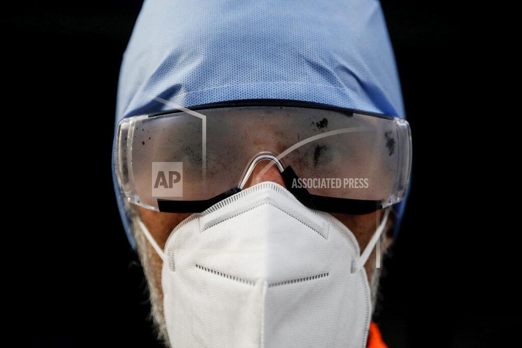 Luca Bruno Medical staffer Paolo Pozzoli looks into the camera with cloudy goggles during his shift at the Biassono White Cross ambulance emergency headquarter, Monza, Italy, Thursday, Nov. 19, 2020. The city of Monza north of Milan is best known for its Formula 1 racetrack. In 2020, it has been the ambulance service that has been doing most of the racing. Over three days that an Associated Press photographer traveled on night calls with an ambulance service, the Monza-Brianza province of some 875,000 bordering Milan added 2,500 new cases, part of Italy’s new epicenter in the Lombardy region. (AP Photo/Luca Bruno)