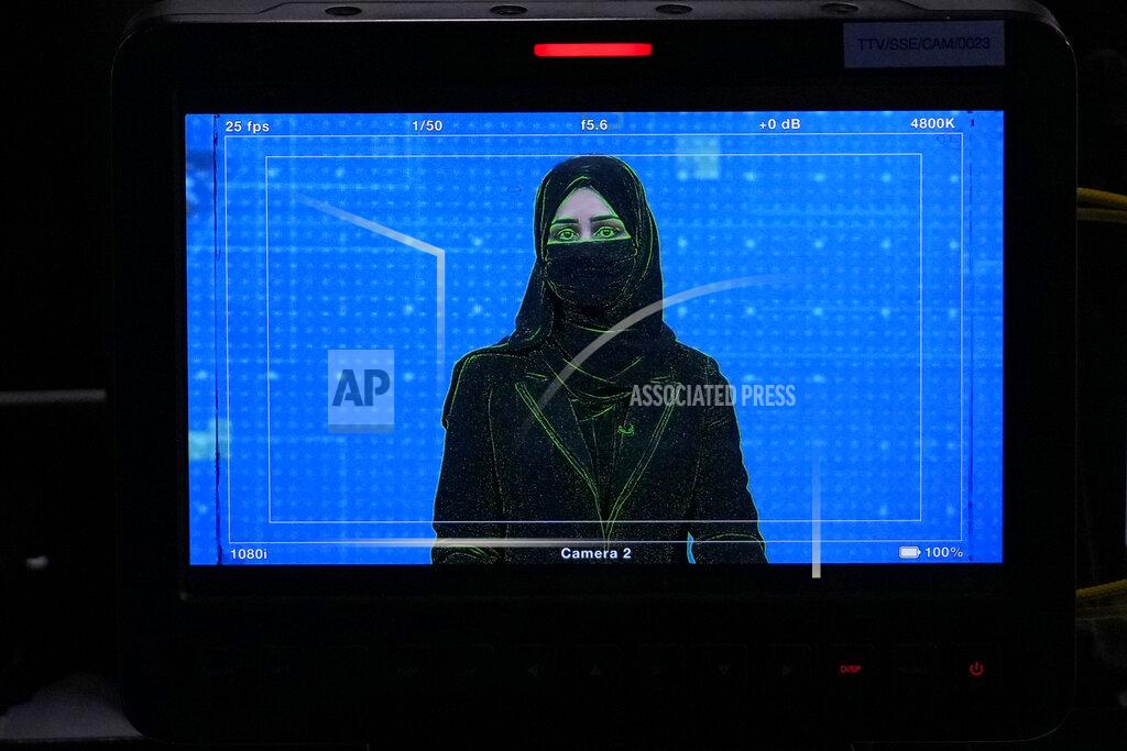 Ebrahim Noroozi TV anchor Khatereh Ahmadi is seen on a studio monitor wearing a face covering as she reads the news on TOLO NEWS, in Kabul, Afghanistan, Sunday, May 22, 2022. Afghanistan's Taliban rulers have begun enforcing an order requiring all female TV news anchors in the country to cover their faces while on-air. The move Sunday is part of a hard-line shift drawing condemnation from rights activists. (AP Photo/Ebrahim Noroozi)