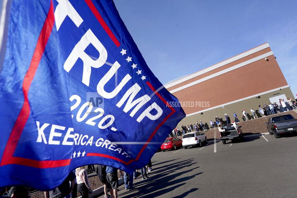 Matt York People wait in line for a shuttle to see President Donald Trump speak at a campaign rally, Monday, Oct. 19, 2020, in Prescott, Ariz. (AP Photo/Matt York)