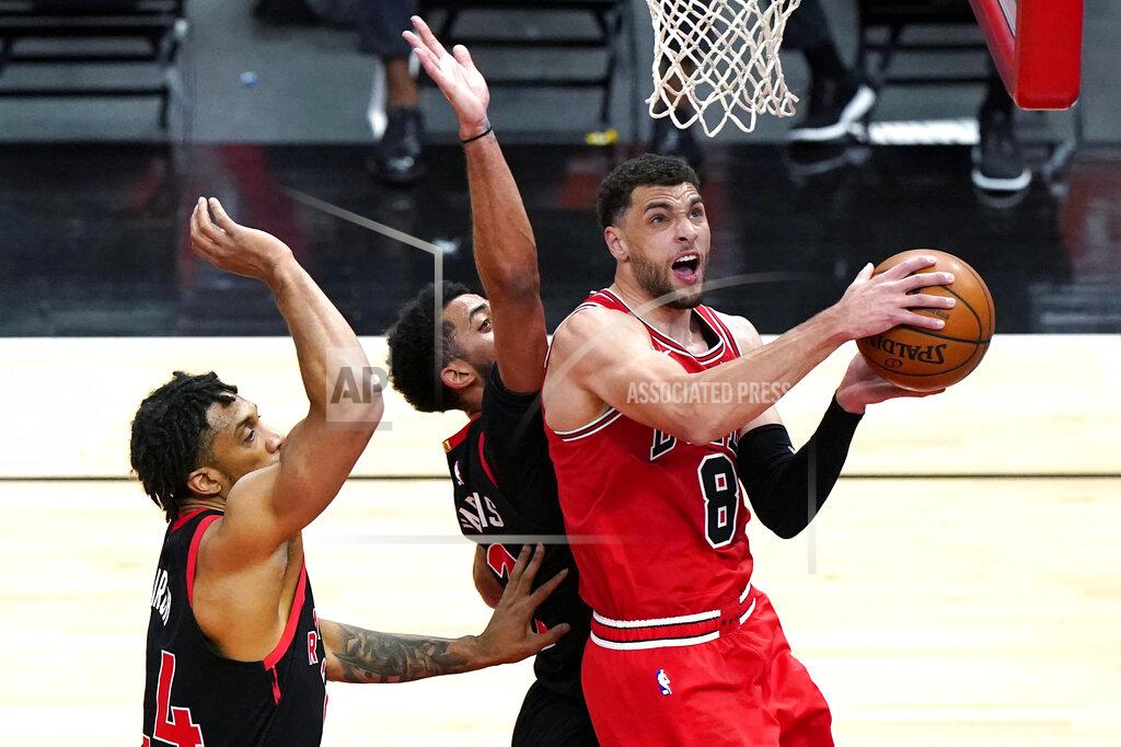 Nam Y. Huh Chicago Bulls guard Zach LaVine, right, drives to the basket against Toronto Raptors center Khem Birch, left, and guard Jalen Harris during the first half of an NBA basketball game in Chicago, Thursday, May 13, 2021. (AP Photo/Nam Y. Huh)