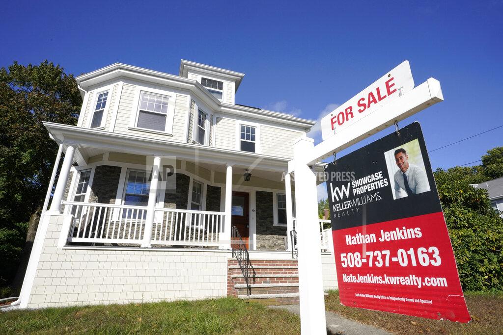 A for sale sign stands in front of a house, Tuesday, Oct. 6, 2020, in Westwood, Mass. U.S. long-term mortgage rates slipped this week as the key 30-year loan marked a new all-time low for the 11th time this year. Home loan rates have notched a year-long decline amid economic anxiety in the recession set off by the coronavirus pandemic. (AP Photo/Steven Senne)
