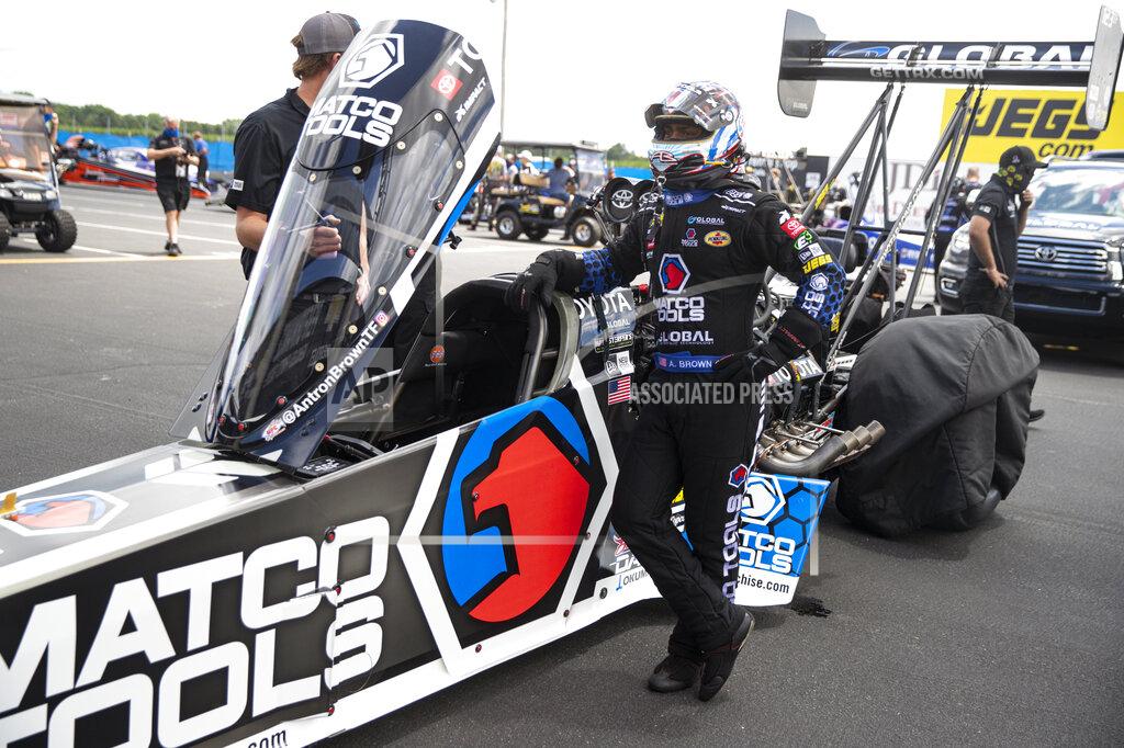 Michael Conroy Antron Brown waits to climbs into his car for a run in Top Fuel during practice for an NHRA drag racing event in Brownsburg, Ind., Friday, July 10, 2020. The NHRA returned to action last weekend near Indianapolis, in front of fans, on network television and amid hopes of a quick financial rebound following a 138-day season suspension. It was the kind of boost everybody needed. Teams and crew members are scrambling to pay the bills. Big questions remain for the world's premier drag-racing series. The pandemic is still a threat to disrupt the season or shut it down again. (AP Photo/Michael Conroy)