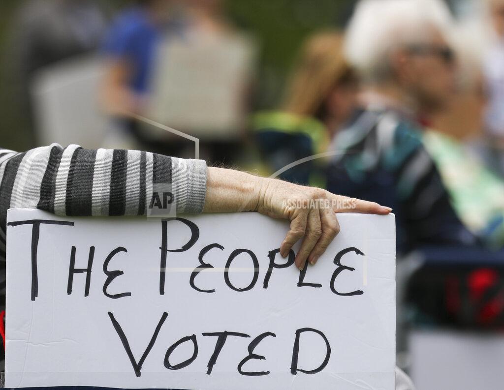 Liv Paggiarino FILE - In this April 27, 2021, file photo, a rally attendee props up a sign with her hand while listening to speakers at the Medicaid expansion rally at the Missouri State Capitol in Jefferson City. The Missouri Supreme Court has vacated a lower court's decision in the state's Medicaid expansion case, agreeing that the voter-approved plan to offer Medicaid to more people should stand. The unanimous decision on Thursday, July 22, 2021, sends the case back to Cole County Circuit Court. (Liv Paggiarino/The Jefferson City News-Tribune via AP, File)