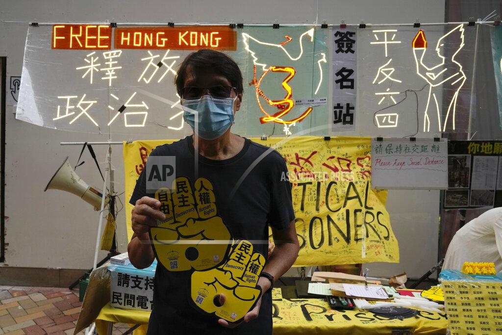Kin Cheung An activist delivers placards to people near the Hong Kong's Victoria Park Friday, June 4, 2021. Police arrested an organizer of Hong Kong's annual candlelight vigil remembering the deadly Tiananmen Square crackdown and warned people not to attend the banned event Friday as authorities mute China's last pro-democracy voices. In past years, tens of thousands of people gathered in Hong Kong's Victoria Park to honor those who died when China’s military put down student-led pro-democracy protests on June 4, 1989. Hundreds, if not thousands were killed. (AP Photo/Kin Cheung)