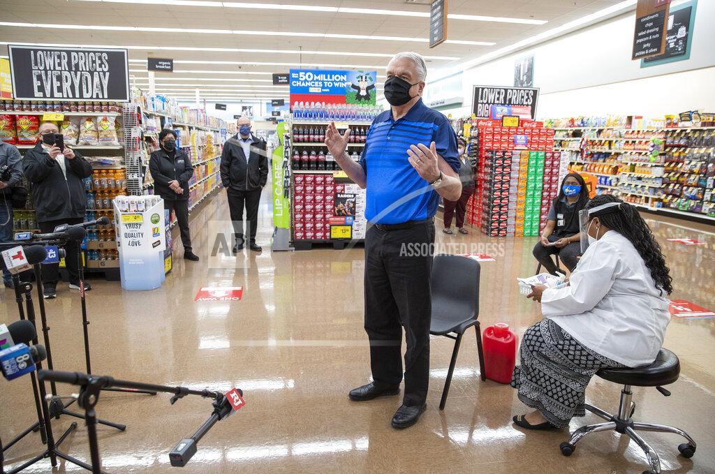 FILE - In this March 11, 2021, file photo, Nevada Gov. Steve Sisolak speaks with reporters after getting a COVID-19 vaccine at a supermarket pharmacy in Las Vegas. Gov. Sisolak's June 1 date for fully reopening Nevada drew a rapid response to reopen legal brothels in one county — and a blunt question to the the state's COVID-19 Task Force about cause-and-effect. (Steve Marcus/Las Vegas Sun via AP, File)