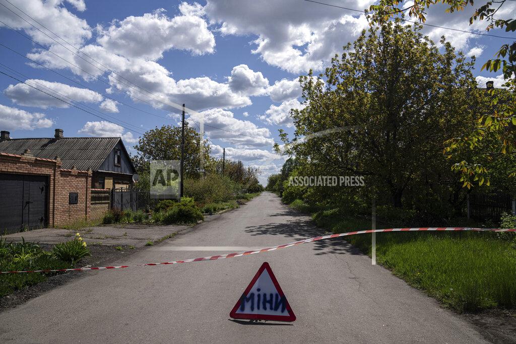 Evgeniy Maloletka A sign that reads "Mines" placed on a road where unexploded devices were found after shelling of Russian forces in Maksymilyanivka, Ukraine, Tuesday, May 10, 2022. (AP Photo/Evgeniy Maloletka)