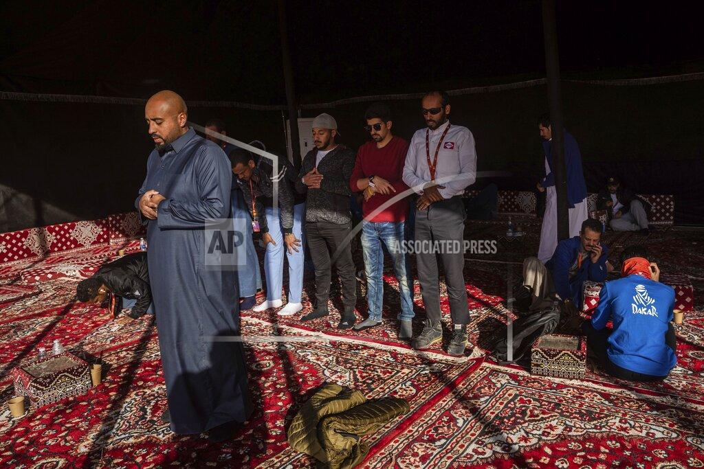 Bernat Armangue In this Monday, Jan. 13, 2020 photo, Muslims pray at a tent after stage eight of the Dakar Rally in Wadi Al Dawasir, Saudi Arabia. Formerly known as the Paris-Dakar Rally, the race was created by Thierry Sabine after he got lost in the Libyan desert in 1977. Until 2008, the rallies raced across Africa, but threats in Mauritania led organizers to cancel that year's event and move it to South America. It has now shifted to Saudi Arabia. The race started on Jan. 5 with 560 drivers and co-drivers, some on motorbikes, others in cars or in trucks. Only 41 are taking part in the Original category. (AP Photo/Bernat Armangue)