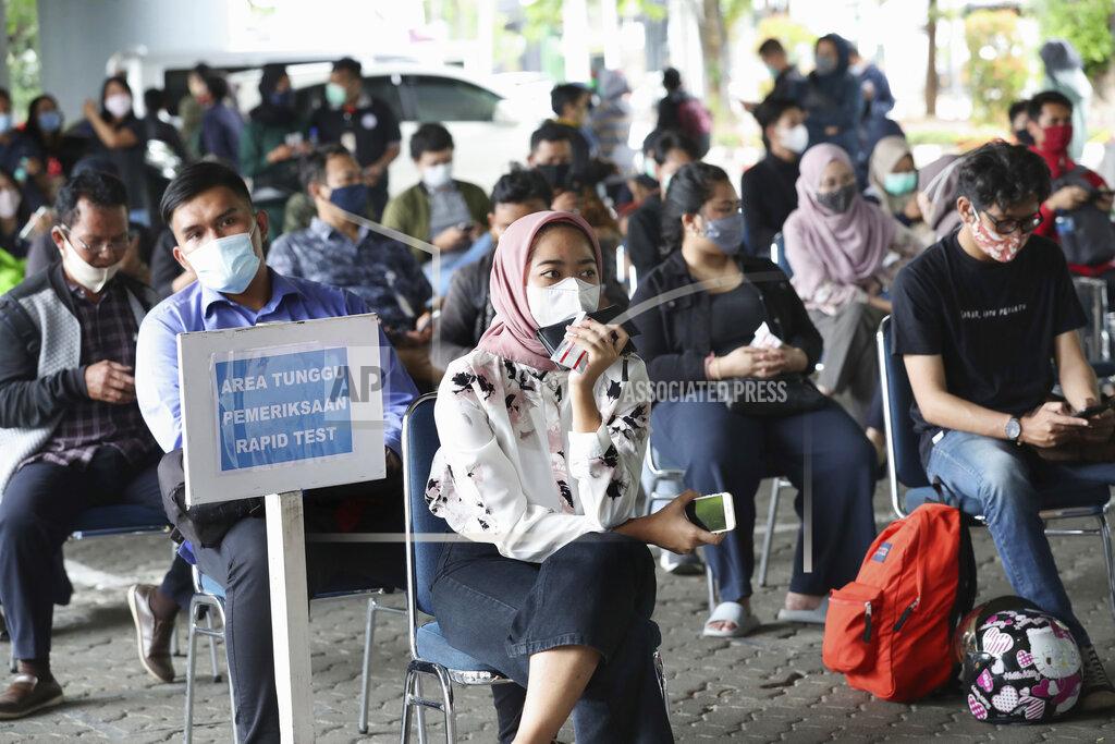 Passengers sit apart to maintain physical distance as they wait to have their nasal swab samples collected to be tested for the coronavirus which is required for long-distance train trips at Gambir Train Station in Jakarta, Indonesia, Tuesday, Dec. 22, 2020. Indonesia has reported more than 600,000 cases of the coronavirus. (AP Photo/Tatan Syuflana)