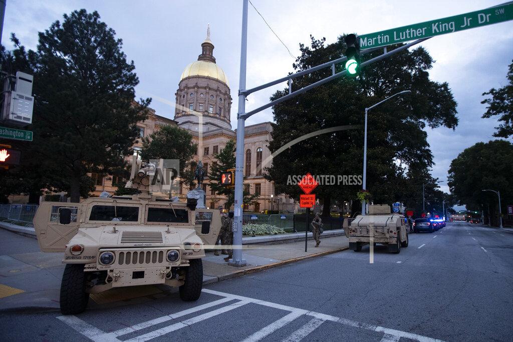 John Bazemore Members of the Georgia National Guard stand outside the State Capitol on Tuesday, July 7, 2020, in Atlanta. Georgia Gov. Brian Kemp mobilized the guard after a surge in gun violence over the weekend. (AP Photo/John Bazemore)