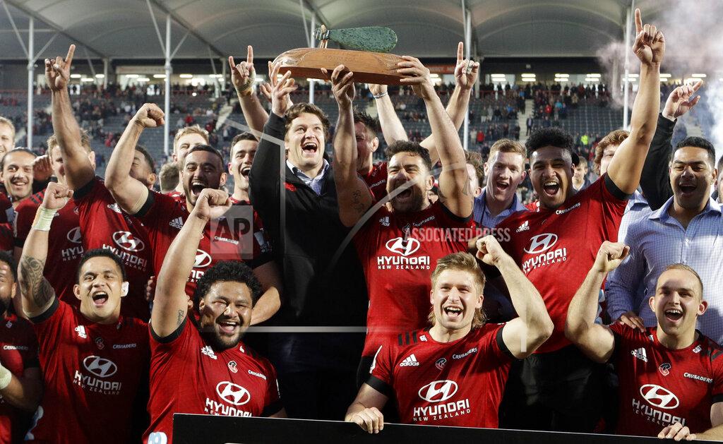 Crusaders Codie Taylor and injured teammate Scott Barrett hold the Super Rugby Aotearoa trophy aloft after defeating the Highlanders in Christchurch, New Zealand, Sunday, Aug. 9, 2020. (AP Photo/Mark Baker)
