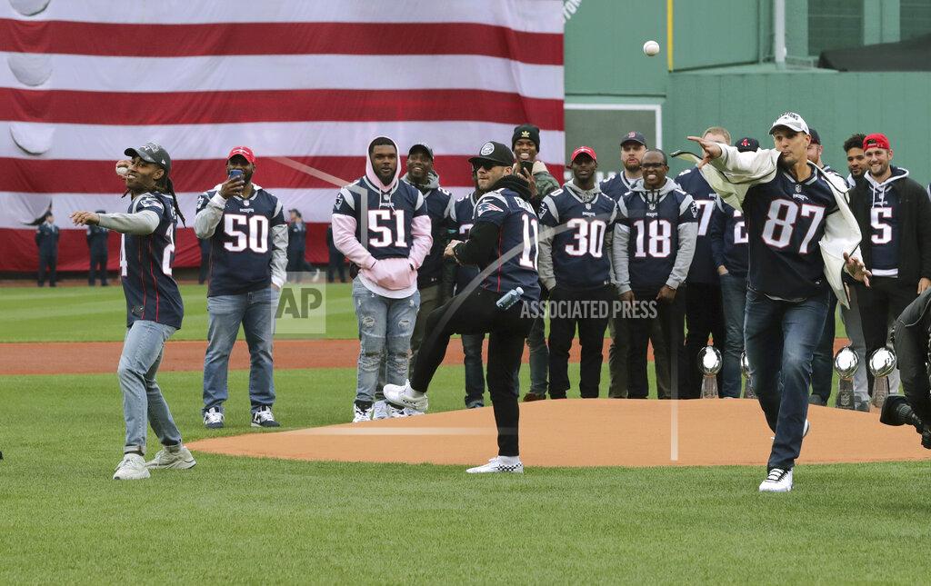 Charles Krupa With Super Bowl winning teammates behind them, New England Patriots' Stephon Gilmore, left, Julian Edelman, center, and Rob Gronkowski, right, toss the ceremonial first pitch before the home opener baseball game between the Red Sox and the Toronto Blue Jays, Tuesday, April 9, 2019, in Boston. (AP Photo/Charles Krupa)