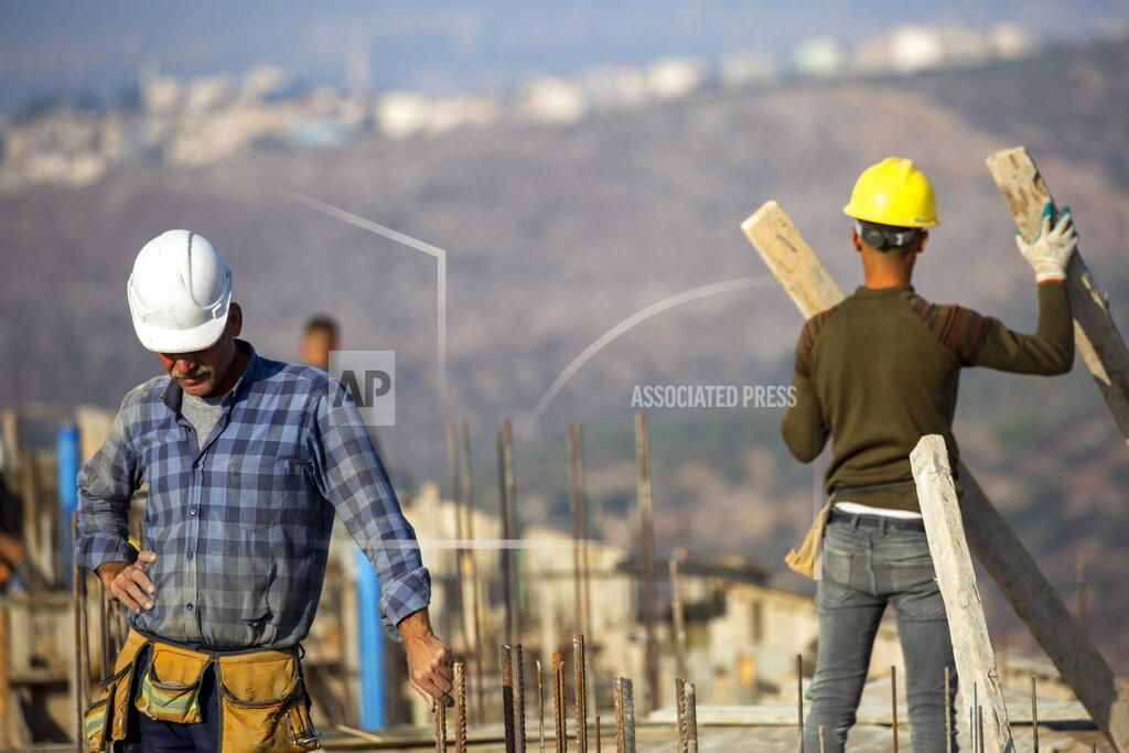 Ariel Schalit Palestinians built new houses in the West Bank Jewish settlement of Bruchin near the Palestinian town of Nablus, Monday, Oct. 25, 2021. Israel is expected to move forward with thousands of new homes for Jewish settlers in the West Bank this week, a settlement watchdog group said Sunday. (AP Photo/Ariel Schalit)