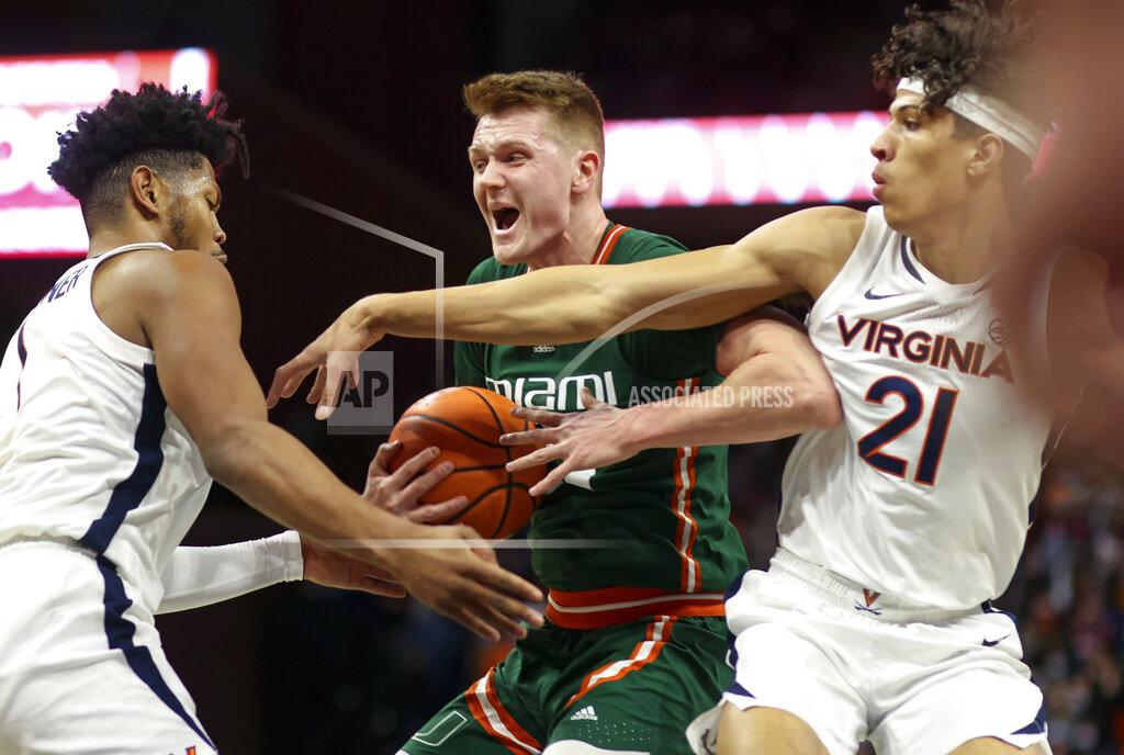 Andrew Shurtleff Miami forward Sam Waardenburg (21) is defended by Virginia forwards Jayden Gardner (1) and Kadin Shedrick (21) during an NCAA college basketball game in Charlottesville, Va., Saturday, Feb. 5, 2022. (AP Photo/Andrew Shurtleff)