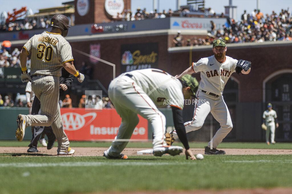 John Hefti San Francisco Giants relief pitcher John Brebbia, right, watches as Giants first baseman Wilmer Flores (41) bobbles the ball and San Diego Padres' Eric Hosmer (30) reaches during the fourth inning of a baseball game in San Francisco, Sunday, May 22, 2022. (AP Photo/John Hefti)