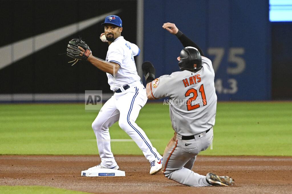 Jon Blacker Toronto Blue Jays' Marcus Semien, left, throws to first to complete a double play against Baltimore Orioles' Trey Mancini after forcing out Austin Hays, right, in the fourth inning of a baseball game in Toronto, Friday, Oct. 1, 2021. (Jon Blacker/The Canadian Press via AP)